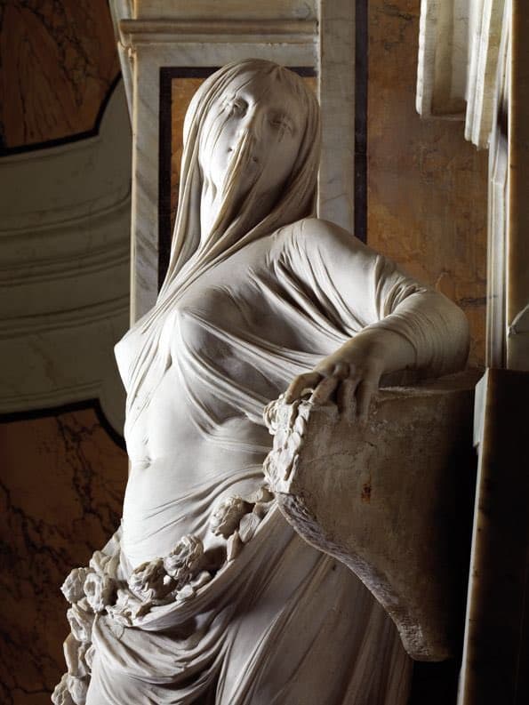 A marble woman covered in a thin clinging veil, her face visible through it, a garland of roses at her hips, resting a hand on a broken tablet — Antonio Corradini, La Pudicizia, 1752
