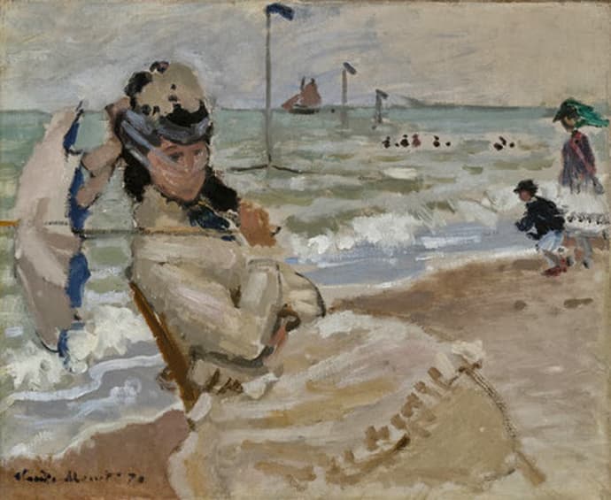 A woman in a pale dress sits on a windy beach holding her hat, a veil blowing across her face and a parasol at her side, with sea and flagpoles behind — Claude Monet, Camille on the Beach at Trouville, 1870