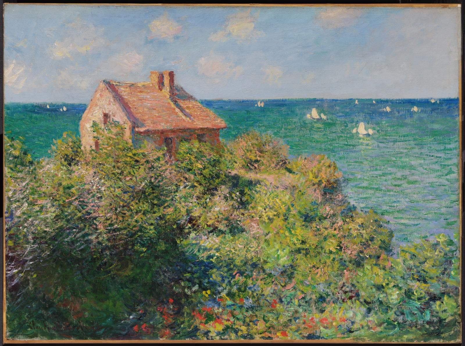 A small stone cottage with a red roof half-buried in flowering shrubs on a clifftop, a jade-green sea full of white sails beyond — Claude Monet, Fisherman's Cottage on the Cliffs at Varengeville, 1882