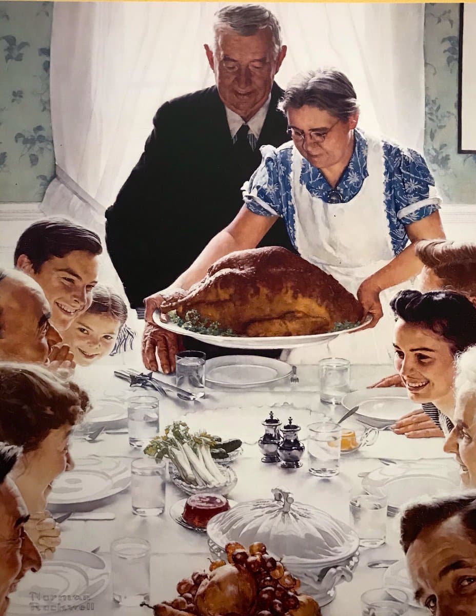 A grandmother sets a large roast turkey on a white-clothed table as a smiling family leans in from both sides — Norman Rockwell, Freedom from Want, 1943