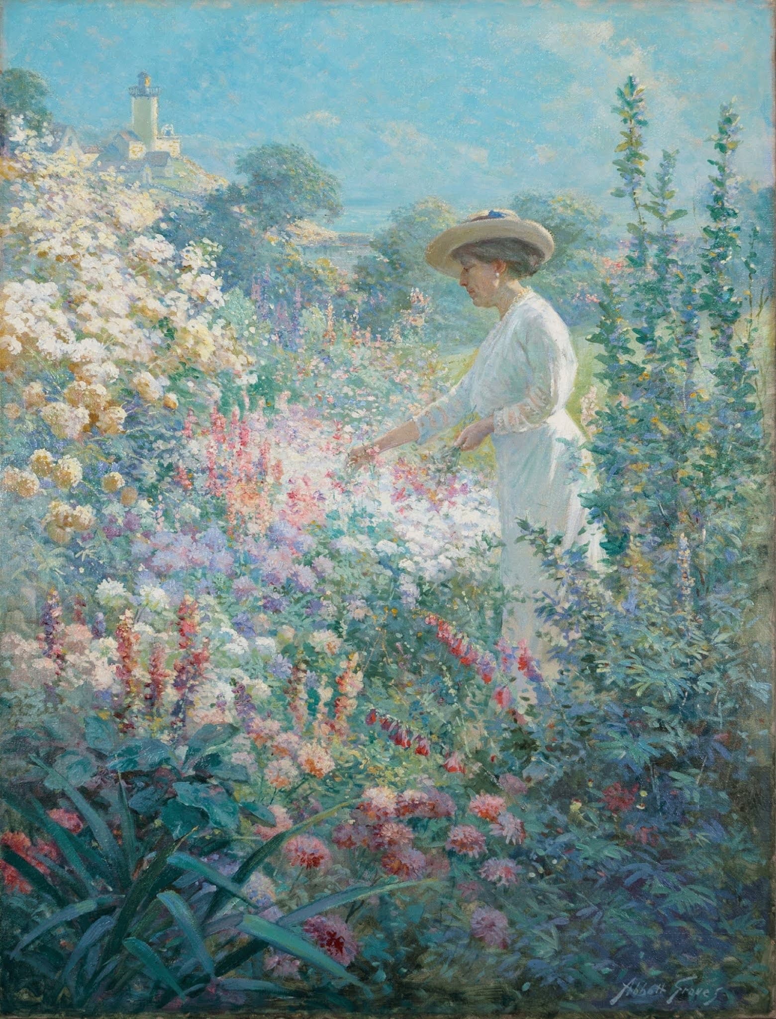 A woman in a white dress and straw hat picks flowers in a tall, dense summer border, a white tower on a hill behind — Abbott Fuller Graves, Garden at Finisterre, 1913