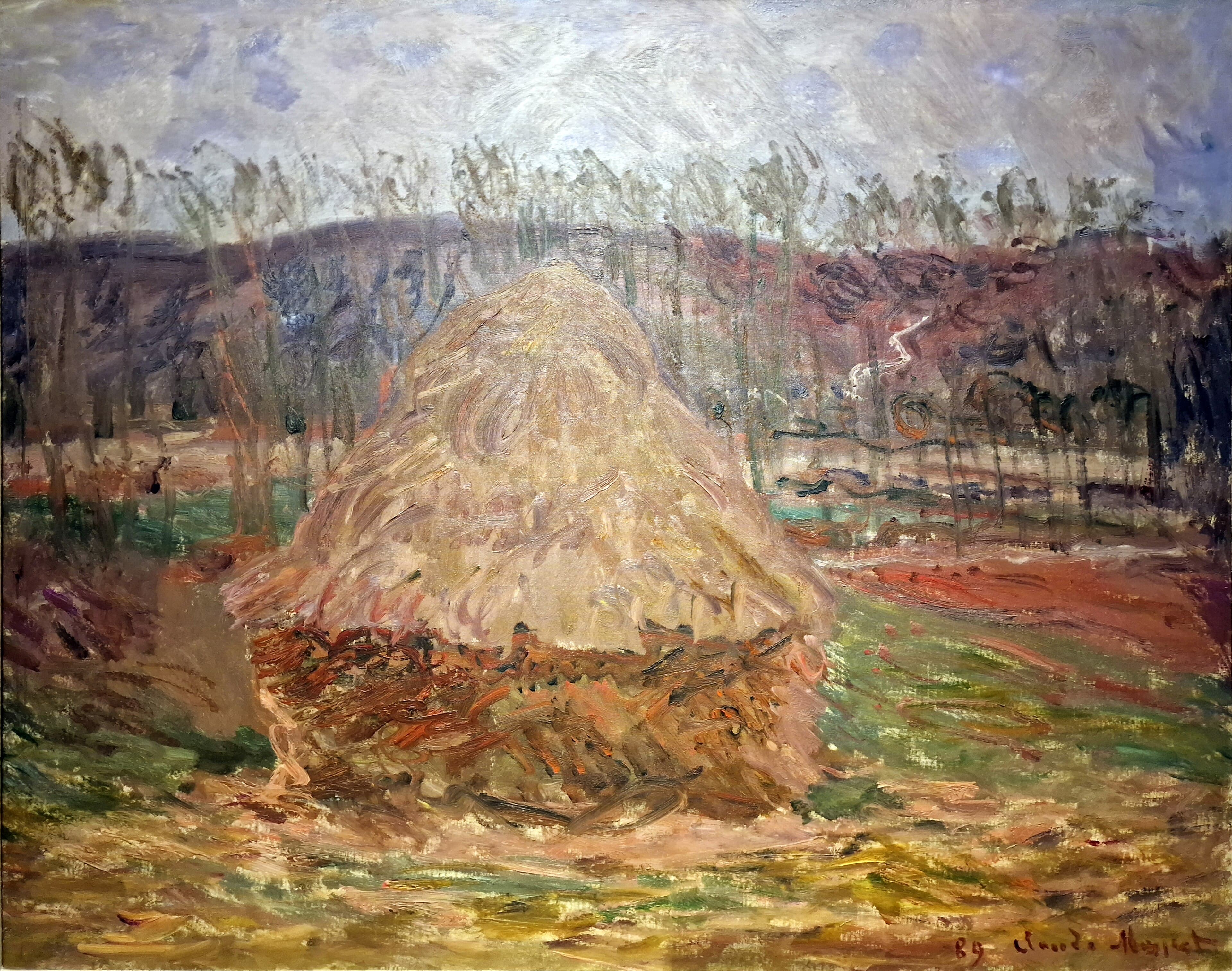 A single pale straw stack on a dark base stands in an autumn field before bare poplars and rust-red and violet hills — Claude Monet, Grainstack at Giverny, 1889