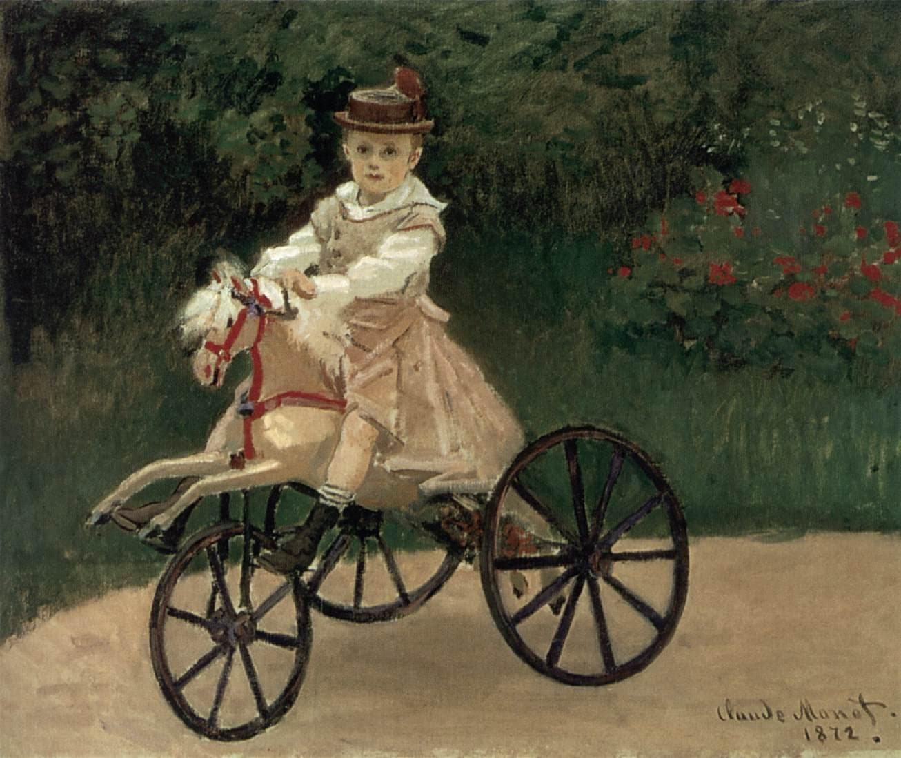 A small boy in a straw hat, white blouse and pink smock sits on a cream wooden horse fixed to three iron wheels on a garden path — Claude Monet, Jean Monet on His Hobby Horse, 1872