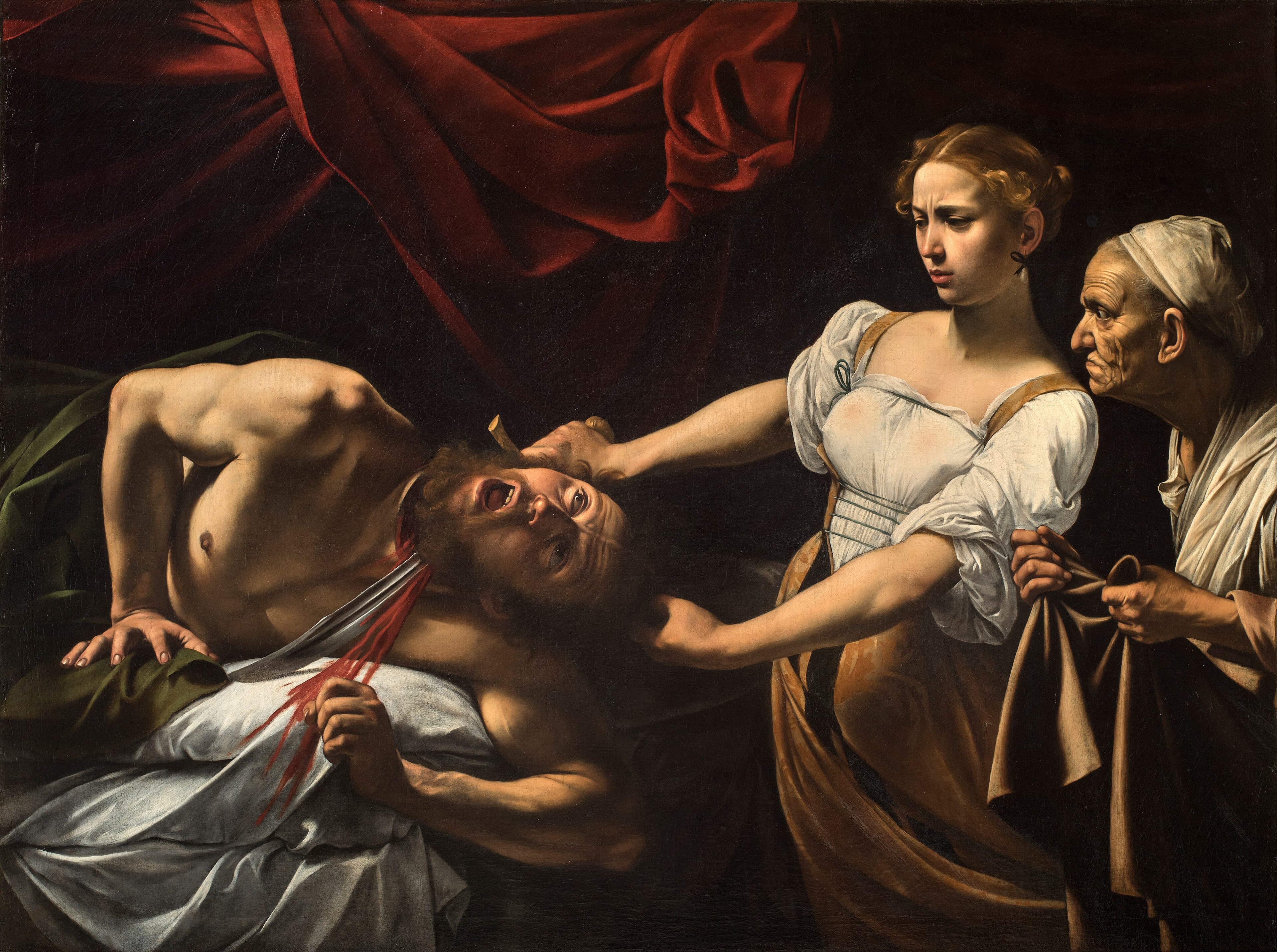 A young woman in a white blouse draws a sword through the neck of a screaming man on a bed while an old maid waits with a cloth, under a red curtain — Caravaggio, Judith Beheading Holofernes, c. 1598–1599