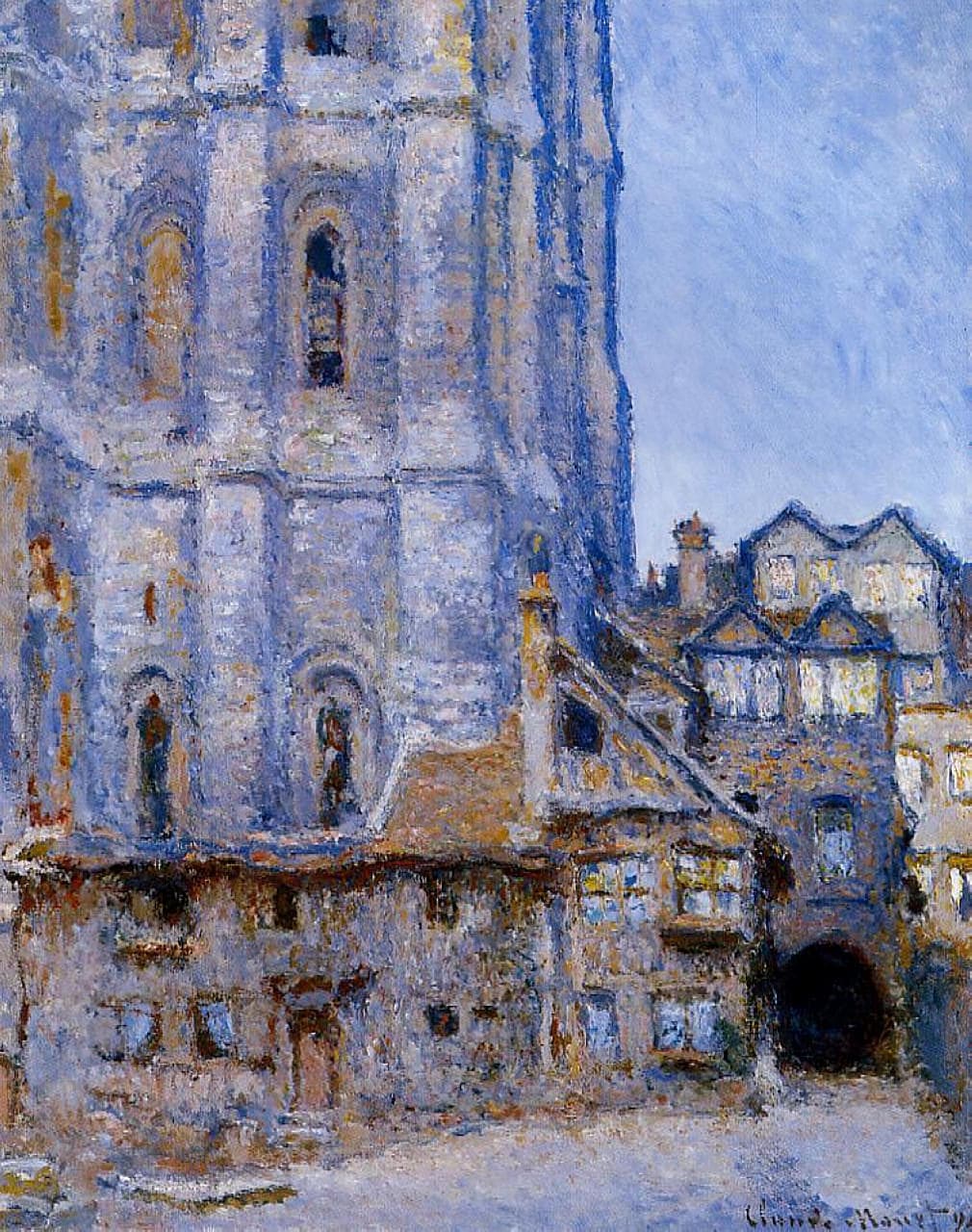 A massive Gothic cathedral tower in lavender and cream rises beside old half-timbered houses and a dark archway under a blue sky — Claude Monet, La Cour d'Albane, Rouen, 1892