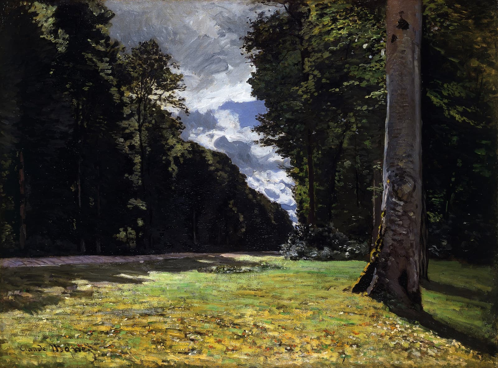 A sunlit grassy clearing between dark forest trees and a great gray beech trunk, under a gap of blue sky and white storm clouds — Claude Monet, The Pavé de Chailly in the Forest of Fontainebleau, 1865