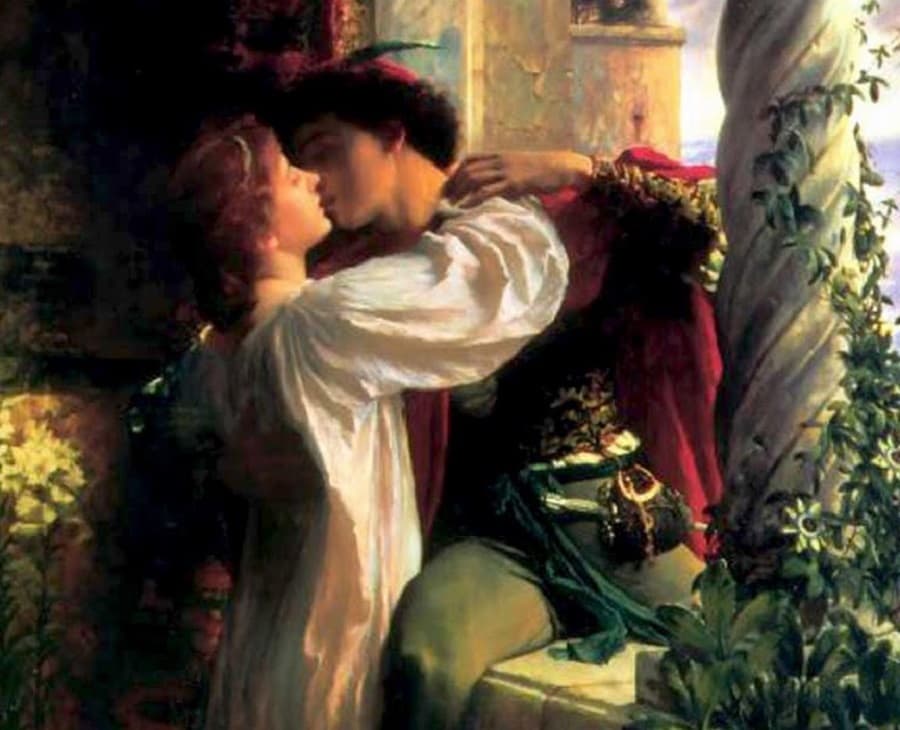Juliet in a white nightgown embraces and kisses Romeo, who wears a crimson cloak and a sword, on a stone balcony with a vine-wound twisted column — Frank Dicksee, Romeo and Juliet, 1884