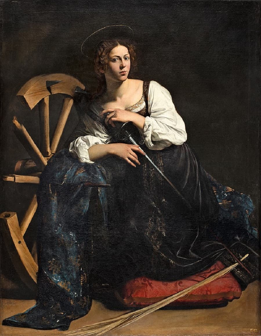 A young woman in a white chemise and dark gold-patterned skirt kneels on a red cushion holding a long sword, beside a broken spiked wheel and a palm frond — Caravaggio, Saint Catherine of Alexandria, c. 1598