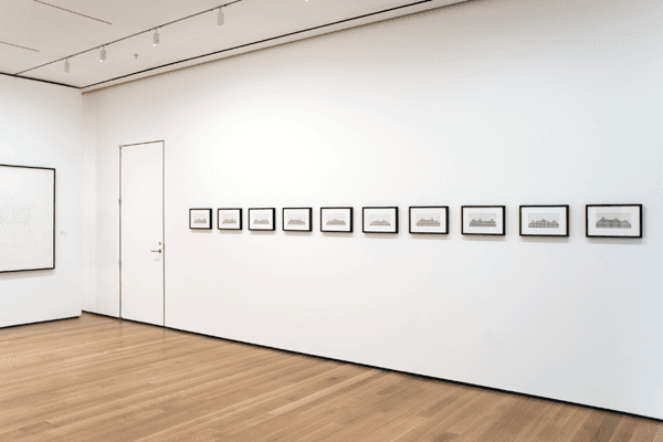 A row of ten small black-framed horizontal drawings with rising grey bar-like profiles hangs on a white gallery wall — Jonathan Horowitz, Stairmaster Suite, 1996