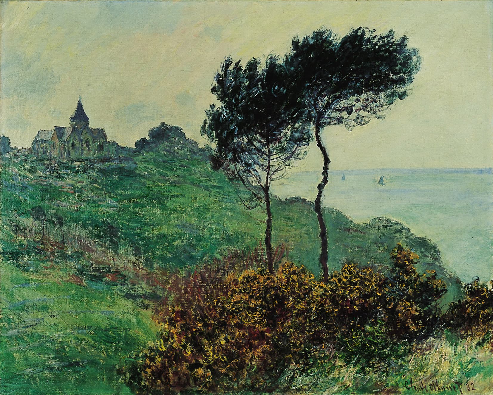A small gray church on a green clifftop, two tall wind-bent pines and golden gorse in front, a pale sea with sails at right — Claude Monet, The Church at Varengeville, Grey Weather, 1882