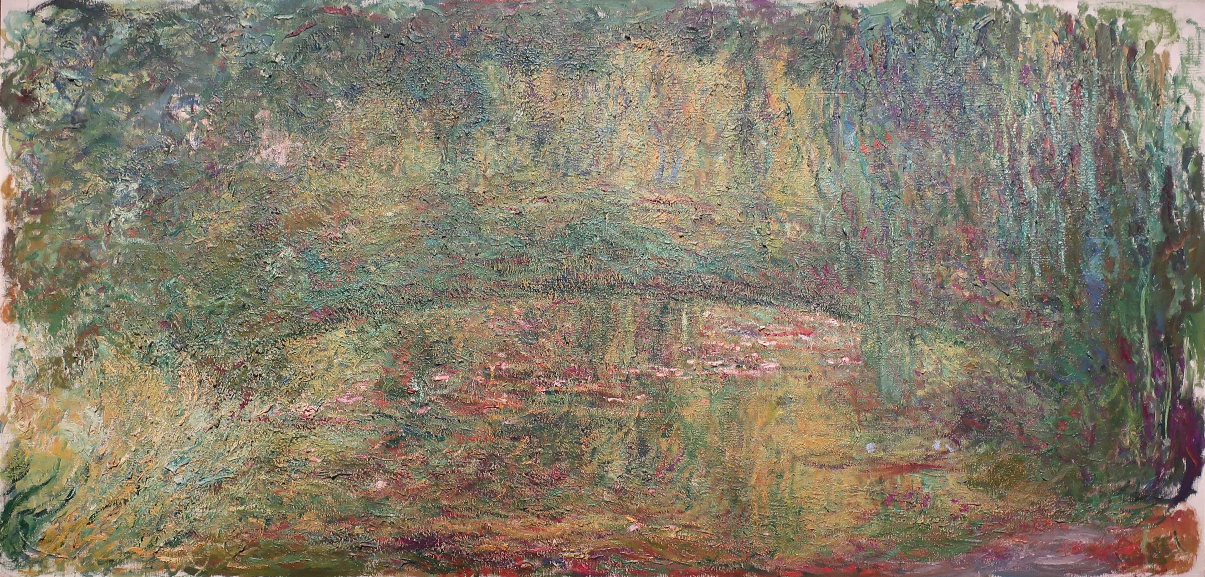A long green footbridge arch dissolves into dense green, gold and pink foliage above a lily pond, a willow at right — Claude Monet, The Japanese Bridge, 1918