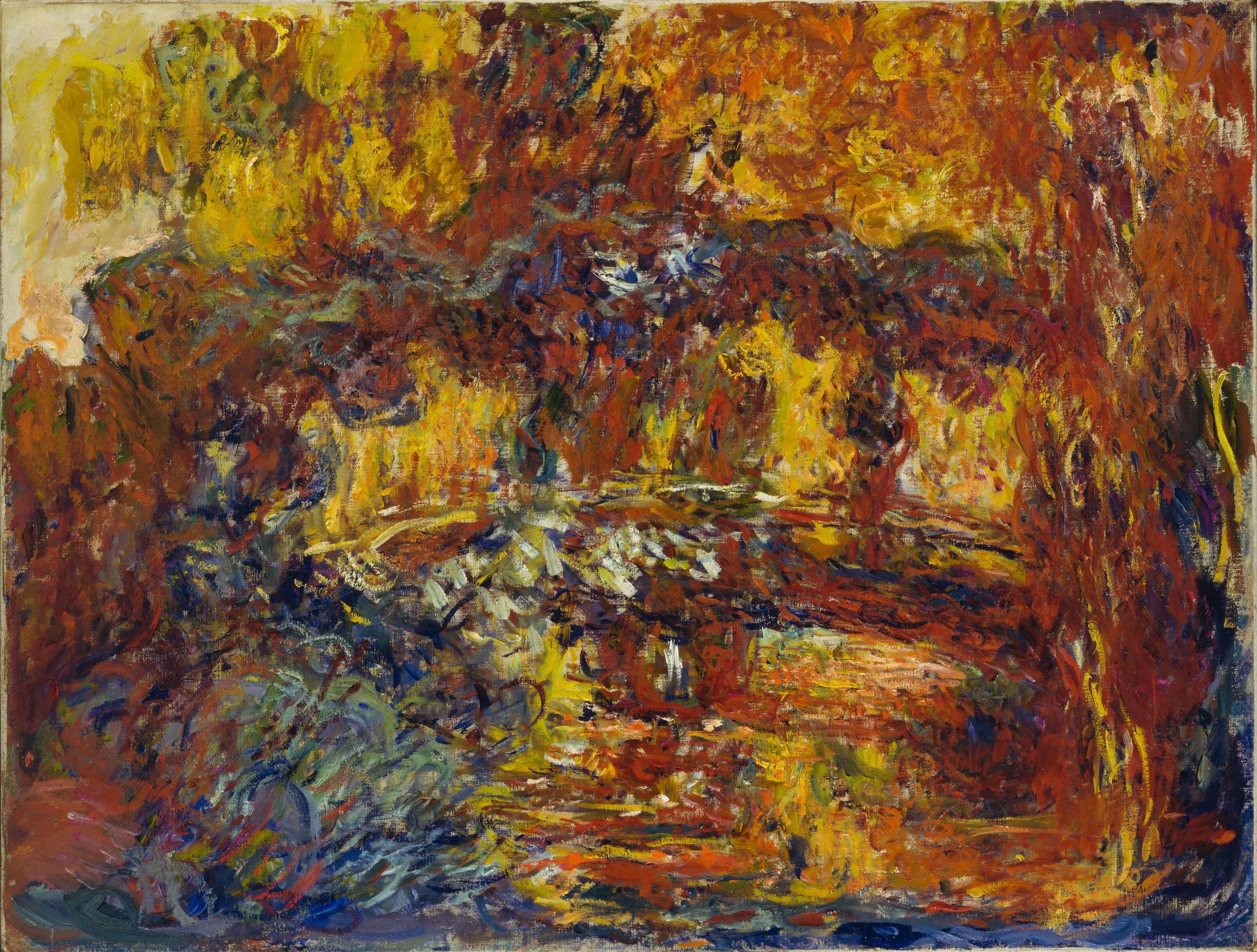A low arched footbridge barely visible beneath a canopy of rust and orange strokes, over a pond of swirling reds and golds — Claude Monet, The Japanese Footbridge, c. 1920–22