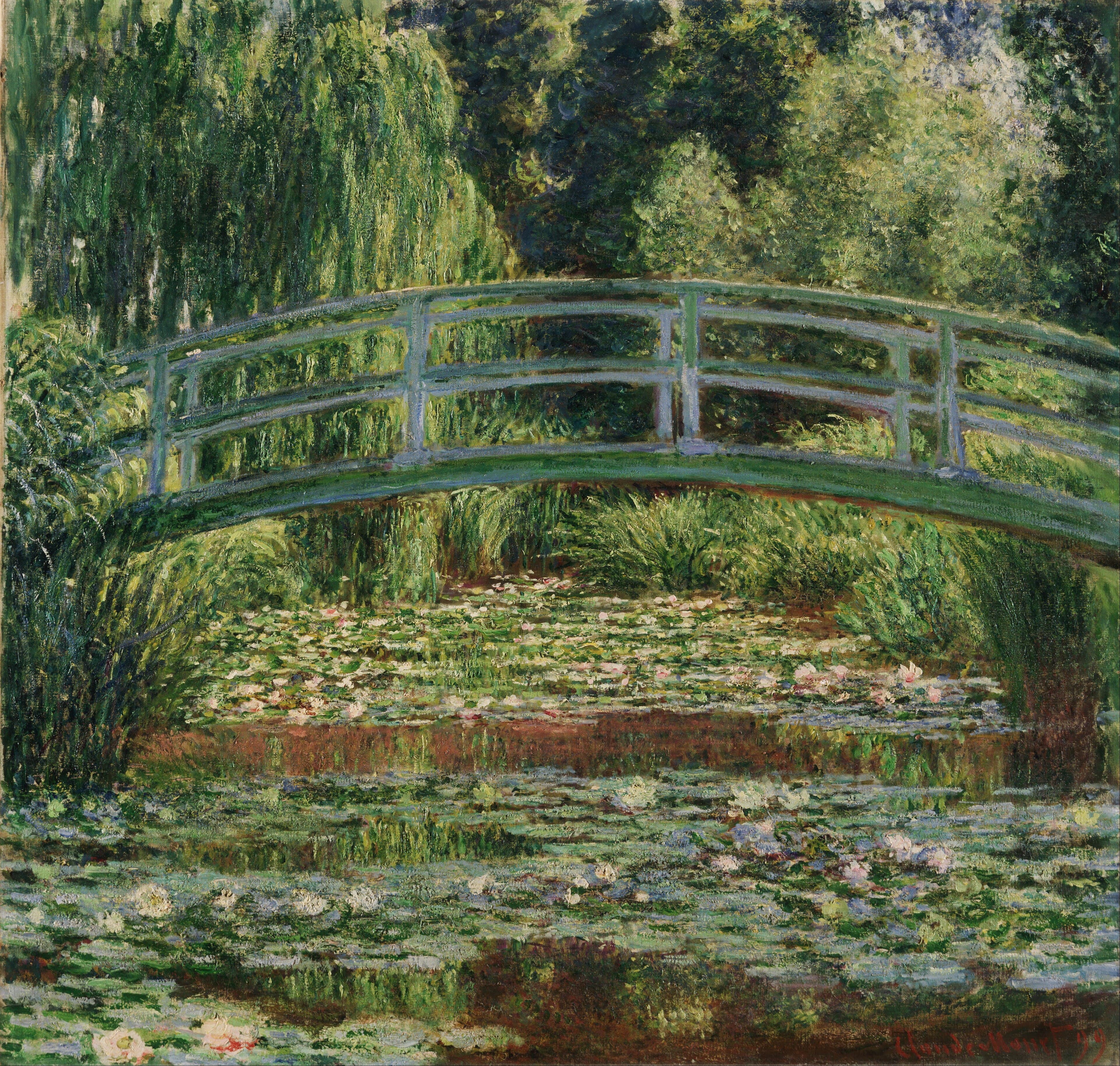 A green wooden footbridge arches across a pond covered with lily pads and pink and white flowers, under a willow and dense trees — Claude Monet, The Japanese Footbridge and the Water Lily Pool, Giverny, 1899
