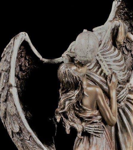 A winged skeleton bends to kiss the forehead of a long-haired youth held in its bony arms, in antiqued bronze finish — Veronese Designs, The Kiss of Death, after El Petó de la Mort