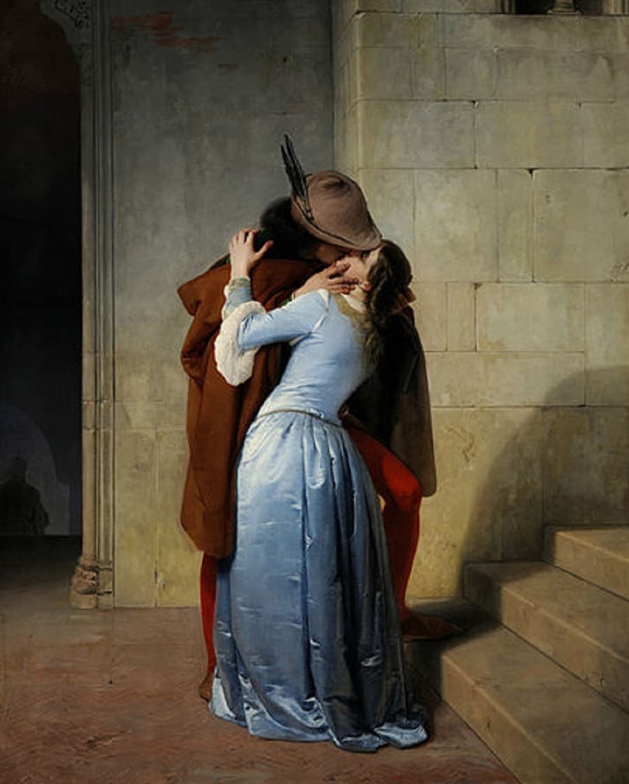 A young man in a brown cloak and feathered hat kisses a woman in a shimmering pale-blue satin gown beside a stone staircase — Francesco Hayez, The Kiss, 1859