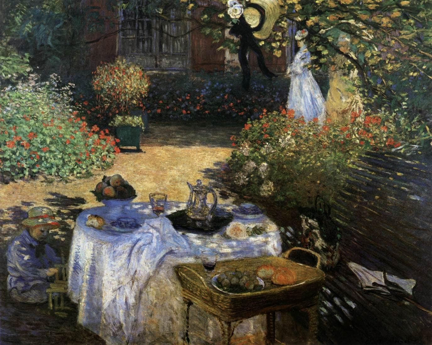 A garden table with a white cloth, fruit, a wine glass and a silver coffee pot stands in dappled shade beside red geraniums, a child playing at left and two women strolling behind — Claude Monet, The Luncheon (Monet's Garden at Argenteuil), c. 1873