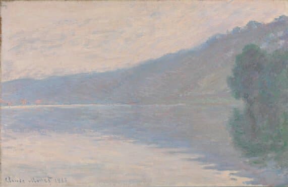 A misty river in pink and mauve with a long hillside sloping down to it and a clump of trees mirrored in the still water at right — Claude Monet, The Seine at Port-Villez, 1894