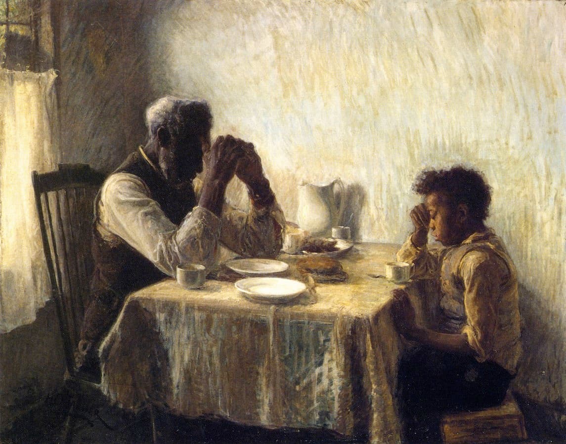 An elderly man and a boy bow their heads in prayer at a small table with plates and a white pitcher, sunlight on the wall behind them — Henry Ossawa Tanner, The Thankful Poor, 1894