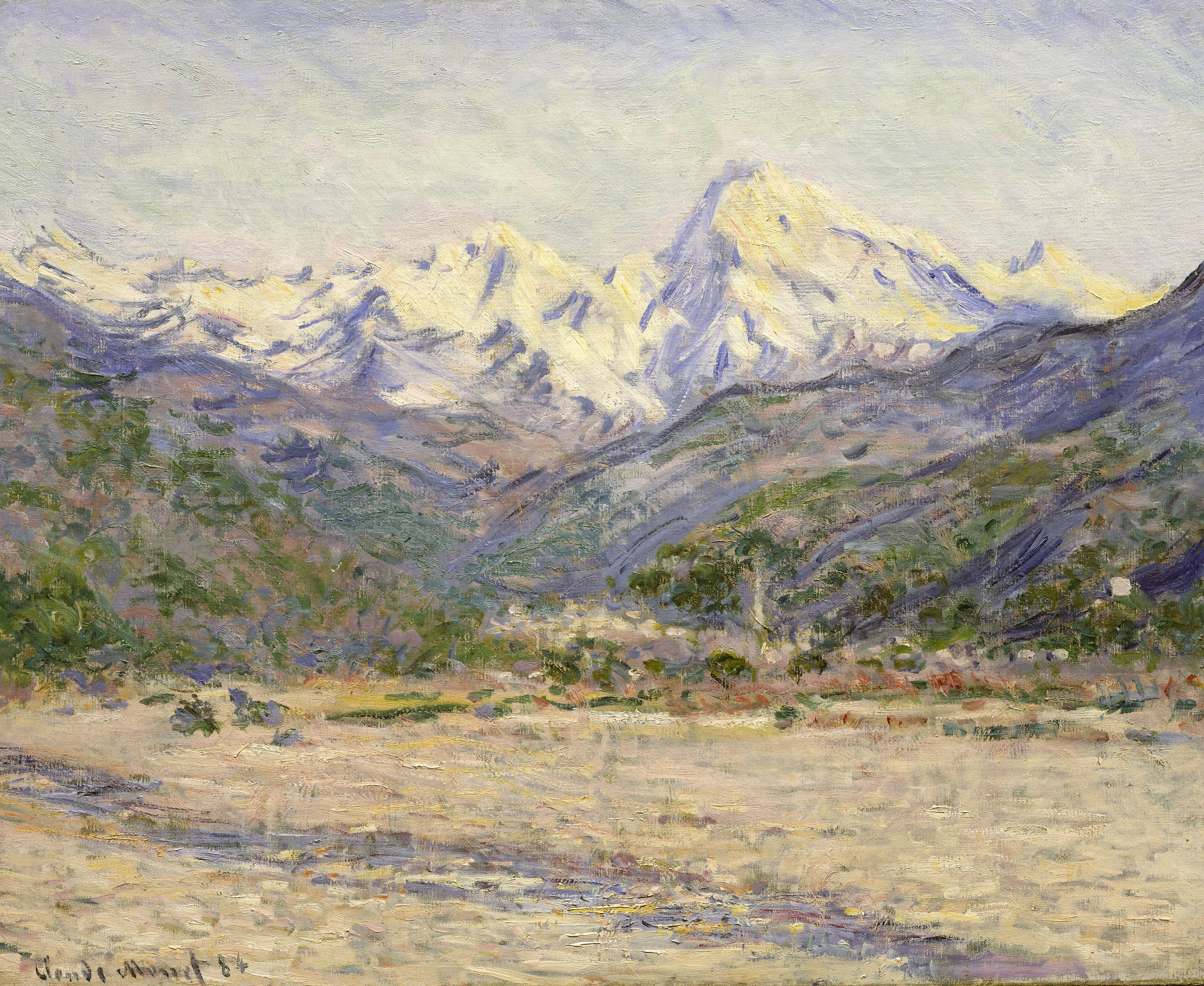 Snow-covered mountain peaks rise above green foothills, a small village and a broad pale riverbed — Claude Monet, The Valley of the Nervia, 1884
