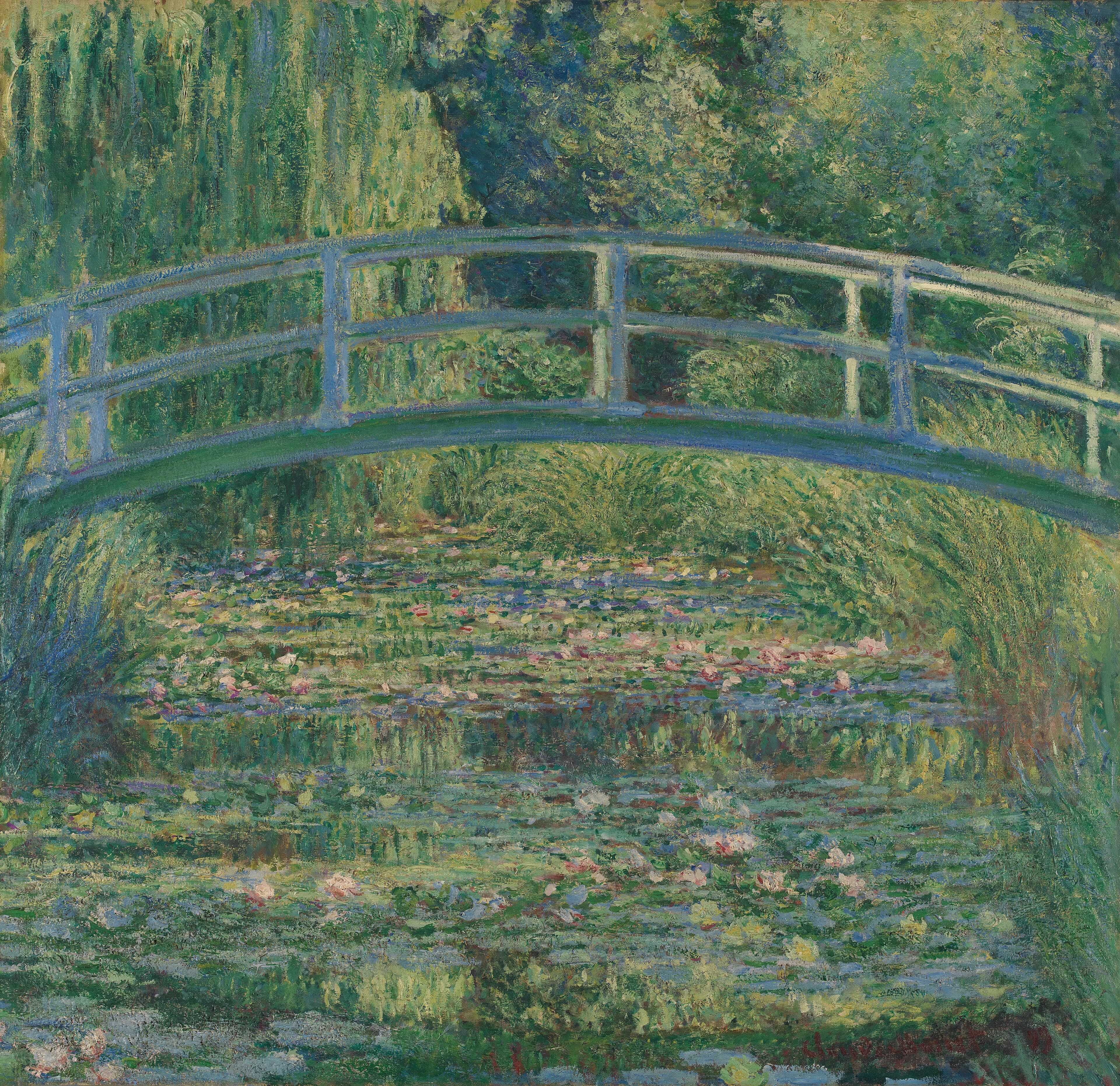 A blue-gray wooden footbridge arches over a pond covered with lily pads and pink flowers, enclosed by willow and dense green trees — Claude Monet, The Water-Lily Pond, 1899