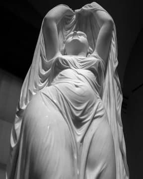 A marble woman raises her arms to lift a wet, clinging veil over her upturned face, the thin drapery revealing her body beneath — Chauncey Bradley Ives, Undine Rising from the Waters, 1880