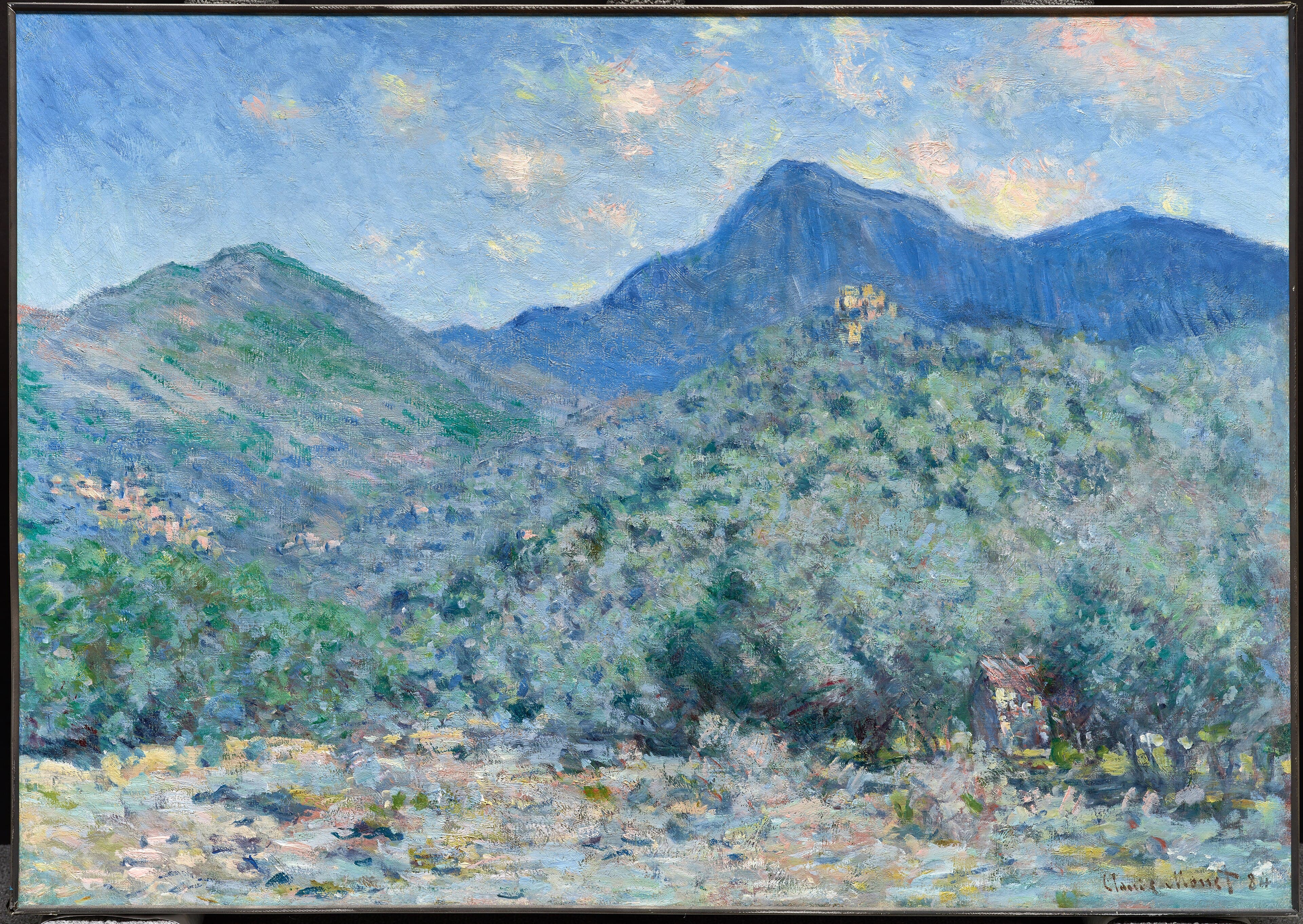 A valley of silvery olive trees with a small hut rises toward a green hill and a tall blue mountain topped by a sunlit village, under a sky with pink clouds — Claude Monet, Valle Buona, near Bordighera, 1884