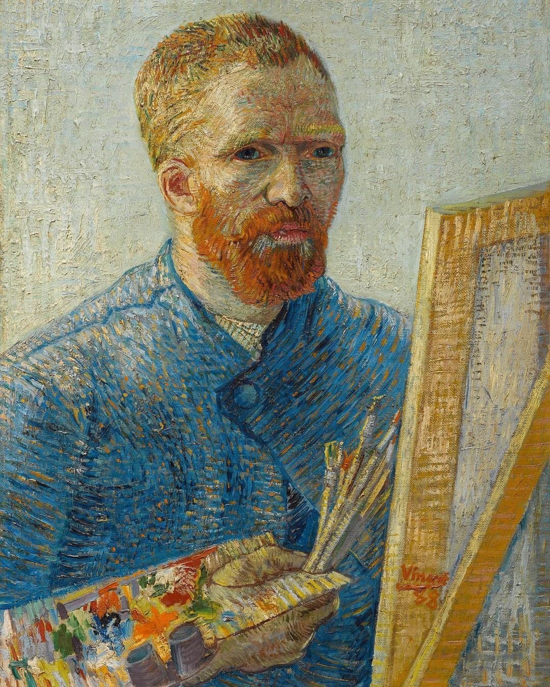 A red-bearded man in a blue smock holds a palette and brushes beside an easel, looking out with a tense stare against a pale background — Vincent van Gogh, Self-Portrait as a Painter, 1887–88