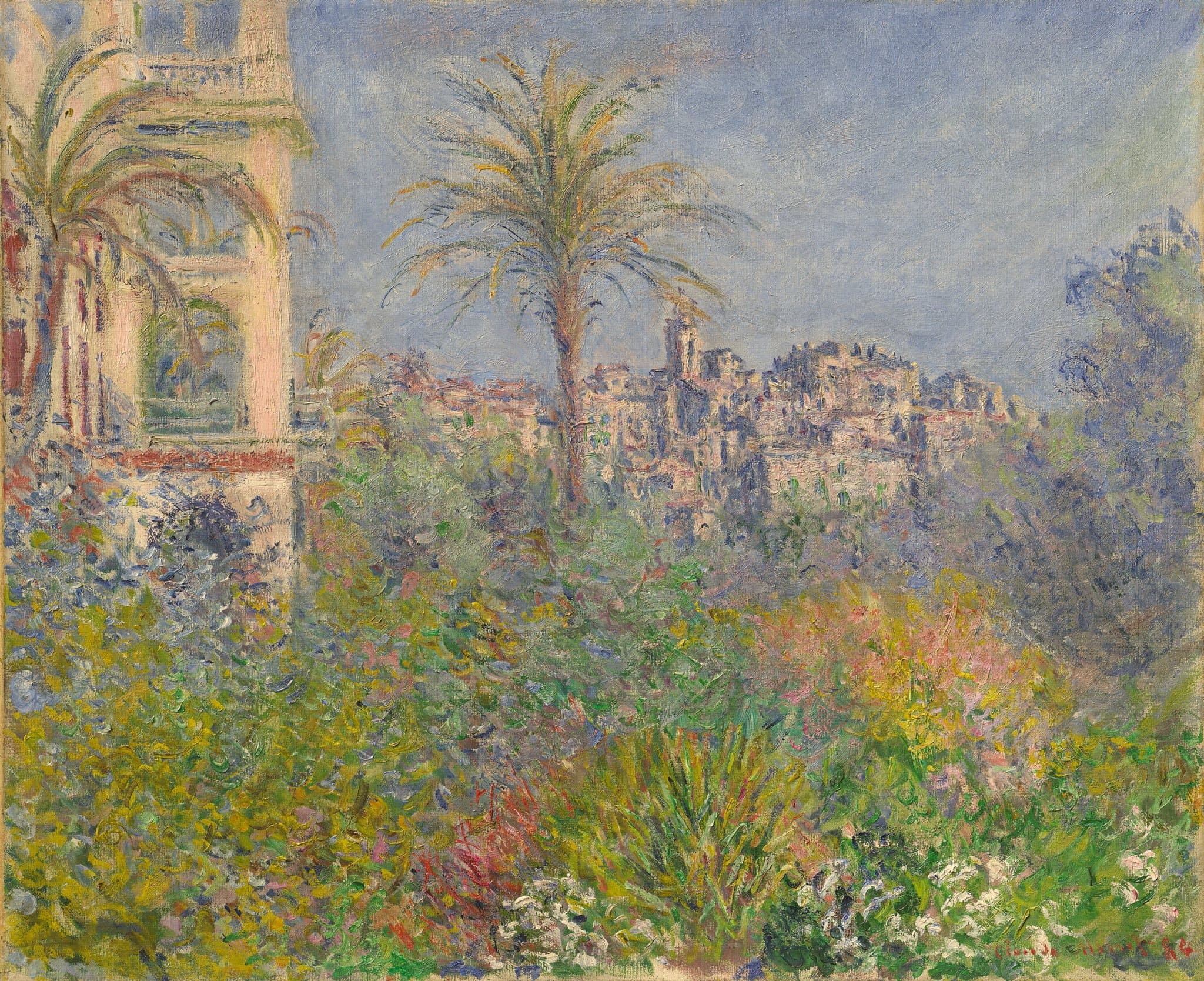 A dense flowering garden with a tall palm fills the foreground, a pale arched villa tower at left and an old hill town with a bell tower behind under a blue sky — Claude Monet, Villas at Bordighera, 1884