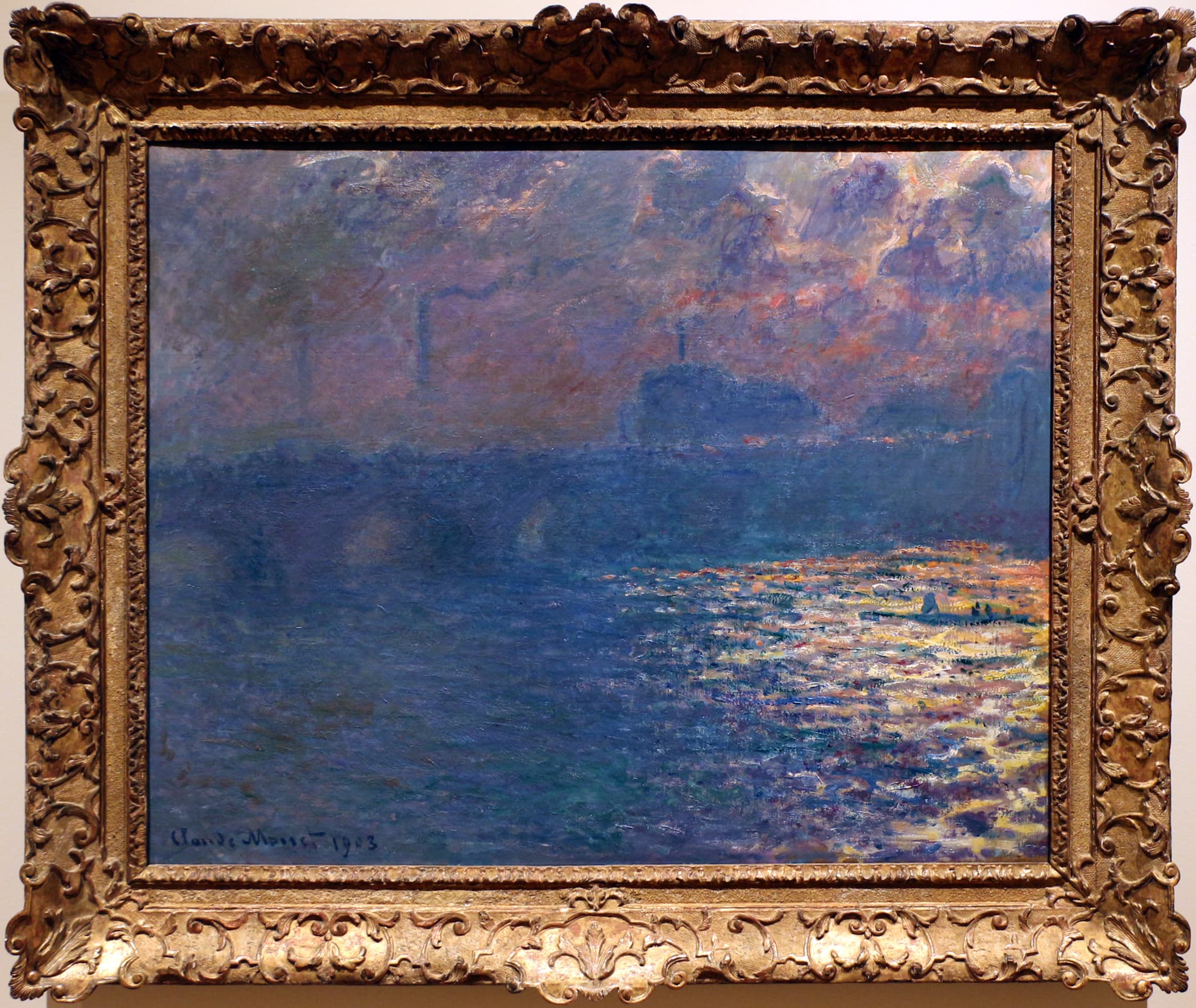 A dark blue bridge silhouetted under violet and orange clouds, the sun blazing a path of yellow light across the river at right — Claude Monet, Waterloo Bridge, Sunlight Effect, dated 1903